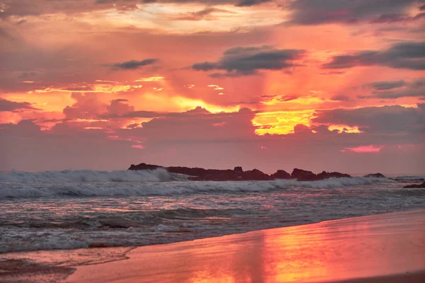 Apus de soare uimitor pe plaja cu vedere la ocean și valuri . — Fotografie, imagine de stoc