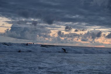 Sahilde okyanus ve dalgalar bakan çarpıcı günbatımı. 