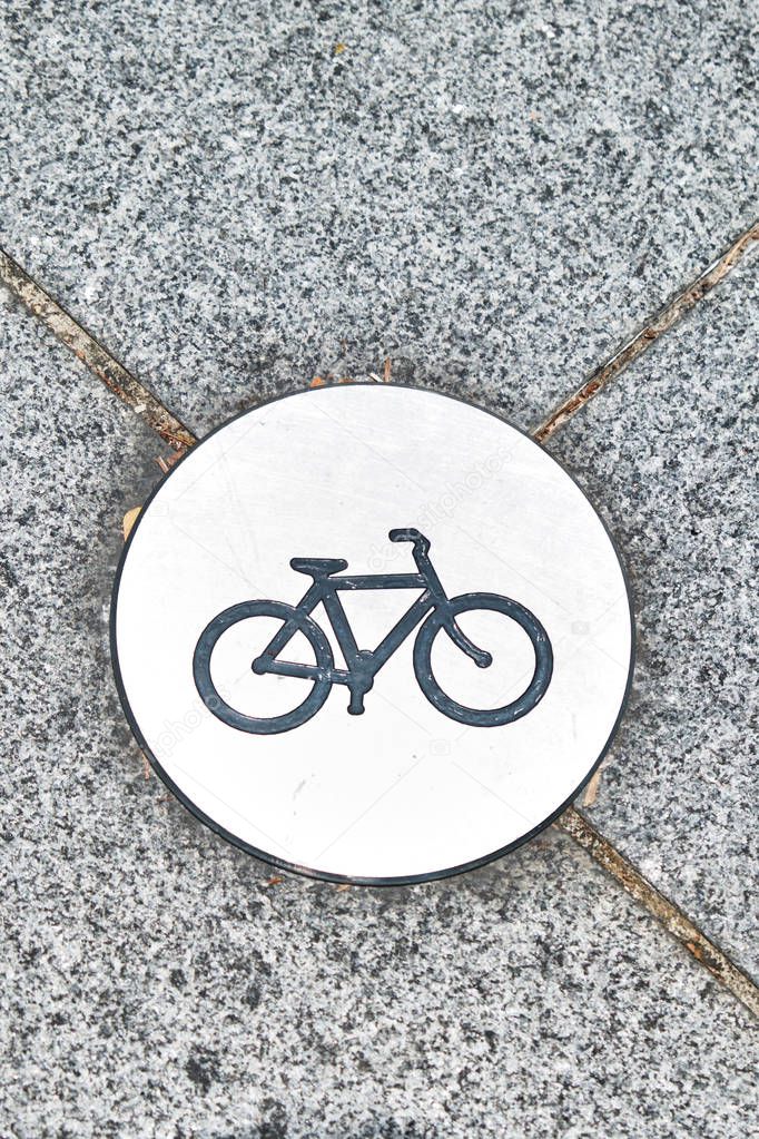 Sign of the bike path on the asphalt in the park.