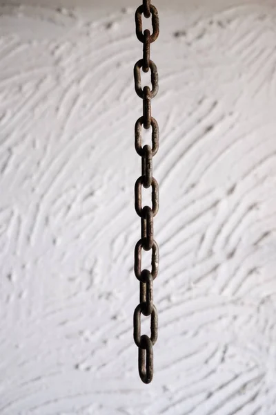 Primer plano de la cadena sobre un fondo de pared blanco — Foto de Stock
