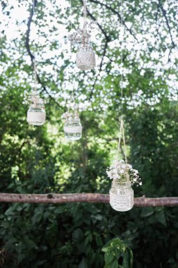 Çiçekli küçük cam kavanozlar. Düğün süsleri