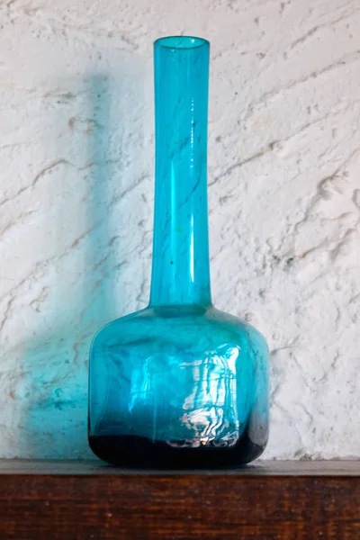 Bombilla azul de vidrio sobre un fondo de pared blanco de cerca Imagen de stock