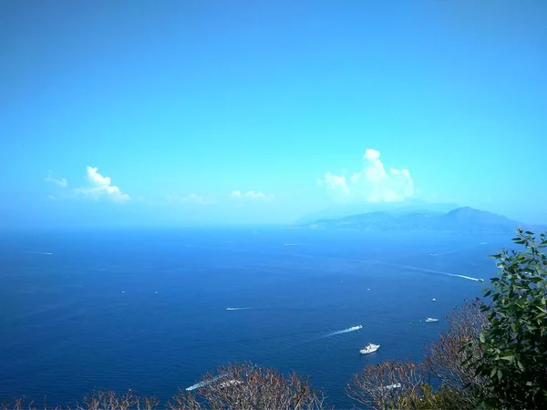 Mer bleue avec yachts et ciel et côte avec vert — Photo