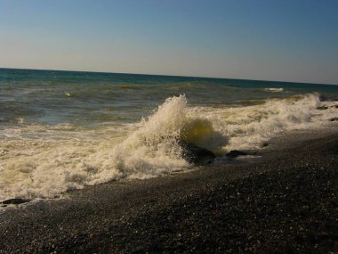 güzel dalga deniz kenarında bir kayanın üzerine çökmesini