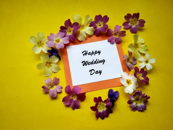 Inskriften lycklig bröllopsdag med blommor på en färgad bakgrund — Stockfoto