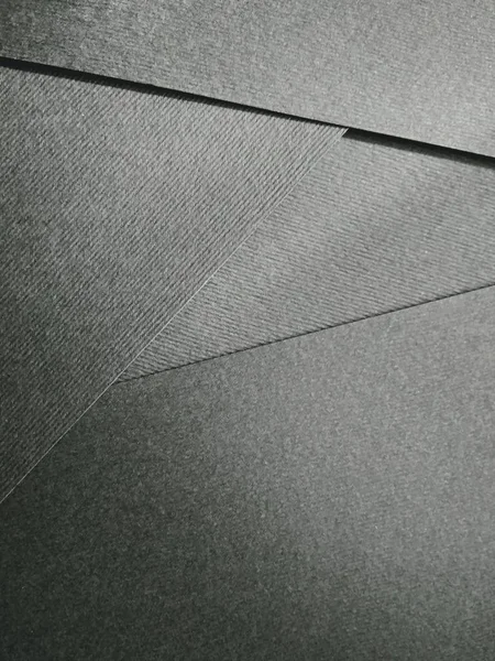 Enkele zwarte papieren gevouwen op tafel dicht omhoog textuur close-up — Stockfoto