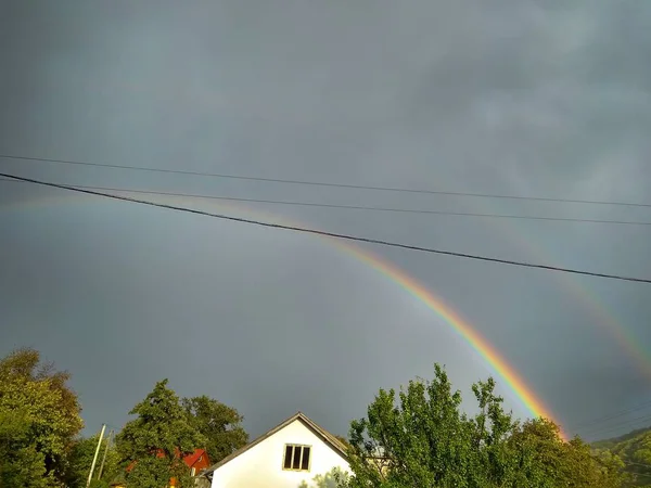 Schöner doppelter Regenbogen vor dunklem Himmel — Stockfoto