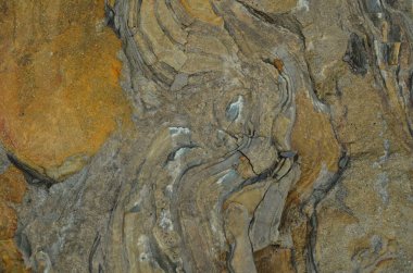 Kaya katmanları - yüzyıllar boyunca yığılmış renkli kaya oluşumları. Etkileyici dokusu olan ilginç bir arka plan..