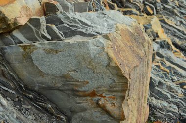 Kaya katmanları - yüzyıllar boyunca yığılmış renkli kaya oluşumları. Etkileyici dokusu olan ilginç bir arka plan..