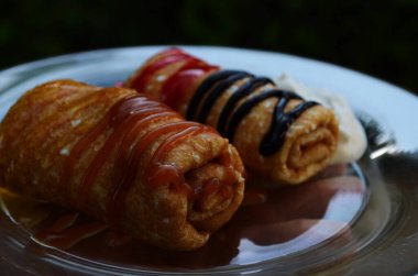 Çikolata, reçel ve bal dolu bir tabakta krep