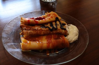 Çikolata, reçel ve bal dolu bir tabakta krep