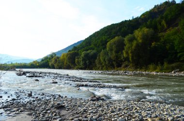 Uçurumlar arasındaki dağ nehri. Nehrin mavi berrak suyu.
