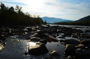 Uçurumlar arasındaki dağ nehri. Nehrin mavi berrak suyu.