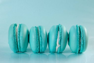 Tatlı badem renkli tiffany renkli mavi makarna veya trendy mavi pastel arka plan izole makarna tatlı kek. Fransız tatlı kurabiyesi. Minimal gıda fırını konsepti. Düz lay üst görünüm kopyalama alanı