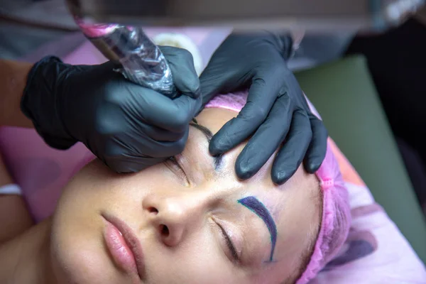 Microblading sopracciglia flusso di lavoro in un salone di bellezza. Donna che ha — Foto Stock