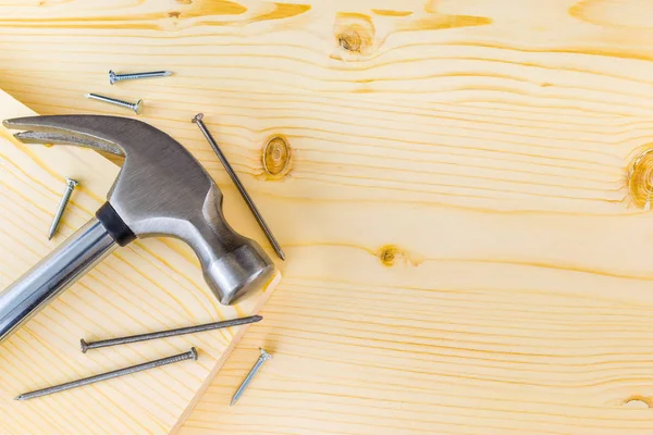 Bodegón plano de martillo y clavos sobre un fondo de madera — Foto de Stock