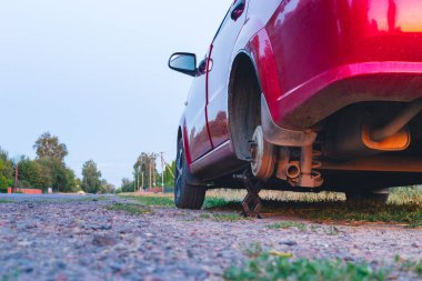 Düz lastik araba servis konsepti. Bir tekerleği çıkararak yol kenarında duran araba. ve bir matkap vida ile yukarı kaldırın.