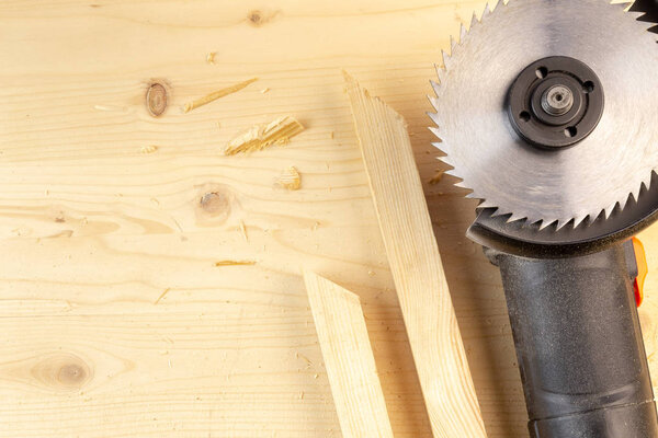 Still life Flat lay of an Electrical Angle grinder with wood cut