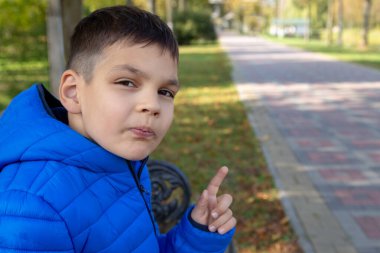 Moda kıyafetleri içindeki çocuk sonbaharda fotokopi alanını işaret ediyor.