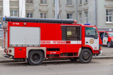 Lutsk, Ukrayna - 28 Şubat 2019: Ukrayna itfaiye teşkilatı motoru kentteki eğitim tatbikatlarında. Yolun kenarına park edilmiş kırmızı bir araç var..  