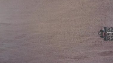 Korkuluklu traktör tarım arazisini ekin ekmeye hazırlıyor.