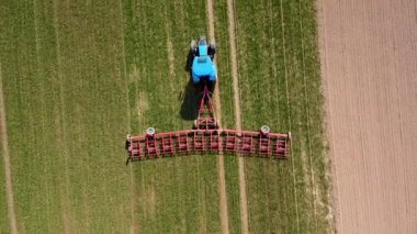 Korkuluklu traktör tarım arazisini ekin ekmeye hazırlıyor.