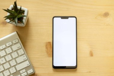 Hayat akıllı bir telefon, not defteri, kalem ve bilgisayar klavyesi ile ahşap bir masa üzerinde makara yapar.. 