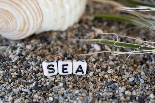 Sea inscription text in a still life of the letters laid out on a shore sand stones