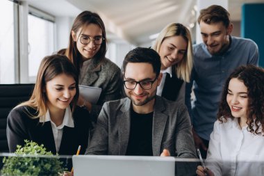 Yeni projesi ile çalışma. Güzel iş adamları bilgisayarları kullanan ve ofiste çalışırken gülümseyen.
