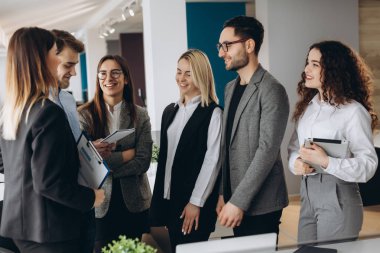 Güzel iş adamları ofis konferansı boyunca aletler kullanıyor, konuşuyor ve gülümsüyor.