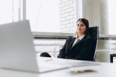 Başarı anlayışı. Onun işyerinde ofiste oturan muhteşem genç businesslady portresi.