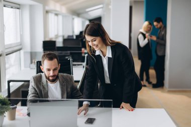 Genç işkadını ve arka planda modern ofis Ofis çalışanları ile birlikte çalıştığı iş adamı.
