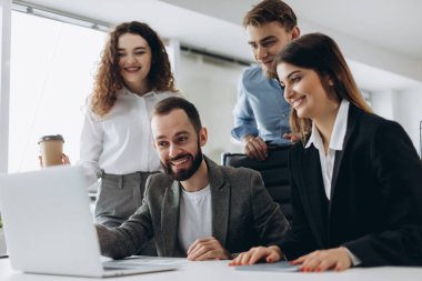 Güzel iş adamları bilgisayarları kullanan ve ofiste çalışırken gülümseyen