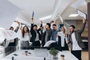 Resmi office zaferini kutluyor mutlu iş takım. Başarılı iş takım kağıt parçaları modern ofiste atar..