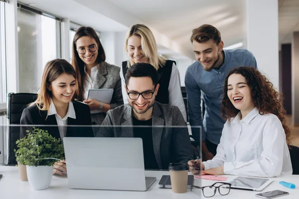 Startup equipo de negocios en la reunión en el interior de la oficina brillante moderna sonriendo y trabajando en el ordenador portátil . — Foto de Stock