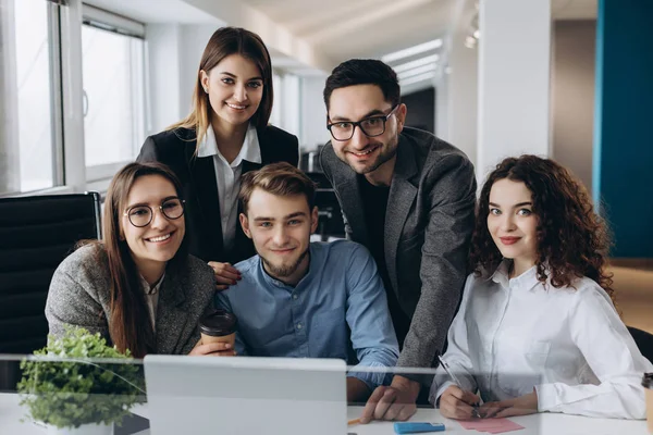 Birlikte modern açık alan office başlangıç içinde çalışan iş takım portresi. Kameraya bakarak