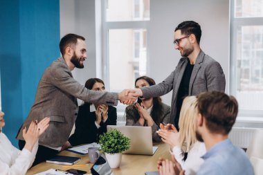 Ofiste tokalaşırken genç iş adamları. Bitirme başarılı Toplantı.