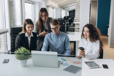 Bir grup meslektaşın bilgisayar üzerinde çalışırken beyin fırtınası yapıyor..