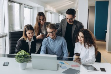 Bir grup meslektaşın bilgisayar üzerinde çalışırken beyin fırtınası yapıyor..
