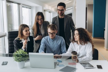 Bir grup meslektaşın bilgisayar üzerinde çalışırken beyin fırtınası yapıyor..