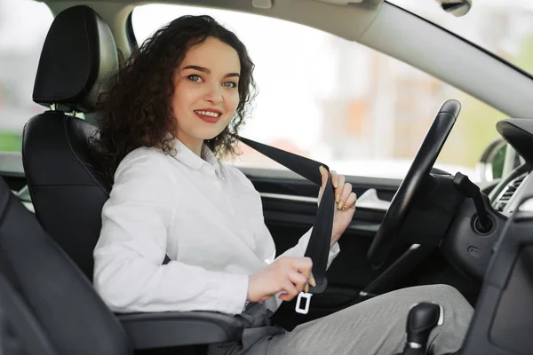 Närbild porträtt av ung kvinna fäst säkerhetsbältet i hennes bil — Stockfoto