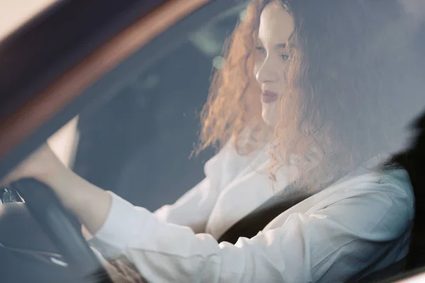 Young woman driving a car in the city. Portrait of a beautiful business woman in a car. Business concept. — Stockfoto