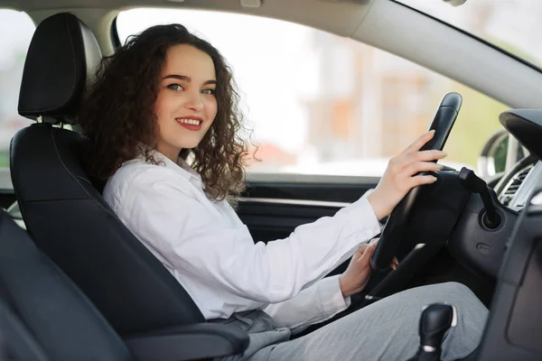 Trygg och vacker. Bakifrån av attraktiva unga affärskvinna som kör en bil. — Stockfoto