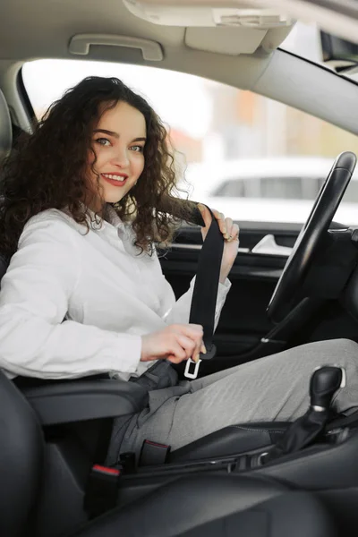 Närbild porträtt av ung kvinna fäst säkerhetsbältet i hennes bil — Stockfoto