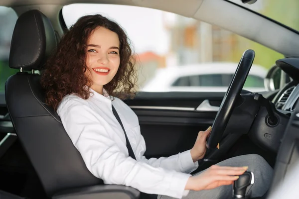 Vackra unga glada leende affärskvinna kör sin nya bil. — Stockfoto