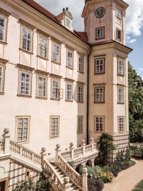 Mnisek pod brdy, Çek Cumhuriyeti - 1 Temmuz 2018: Saat kulesini aydınlatan güneş ışığı ve bir yaz günü Czechia 'da bulunan mnisek pod brdy şatosu merdiveni