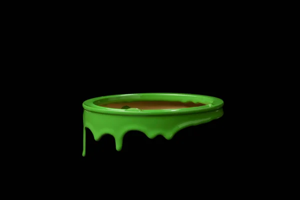 Colorful paint leaking down over the part of metal bucket. Isolated over black background