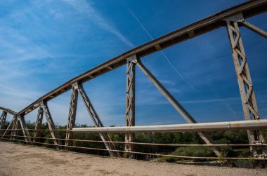 Köprünün üzerindeki eski paslı metal çitler. Kırık asfalt ile yol