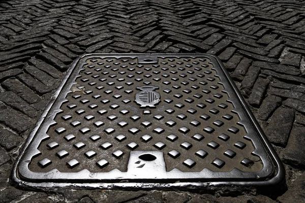 Old shaft cover on the paving street — Stock Photo, Image