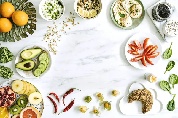 mermer zemin üzerine farklı yemekler, sebze ve meyve ile plakaların üstten görünüm 